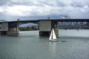 A sail boat sailing (it is what they do best) on the Willamette River in Portland.